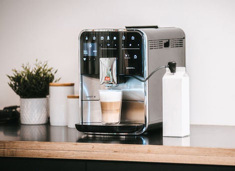 Melitta Barista TS Smart z latte macchiato stojącym na stole